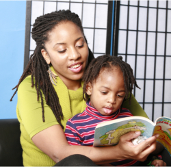 teacher and a young girl reading a book