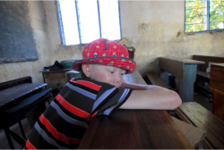 young boy lying on a desk