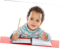 an infant holding pencil with notebook on the table